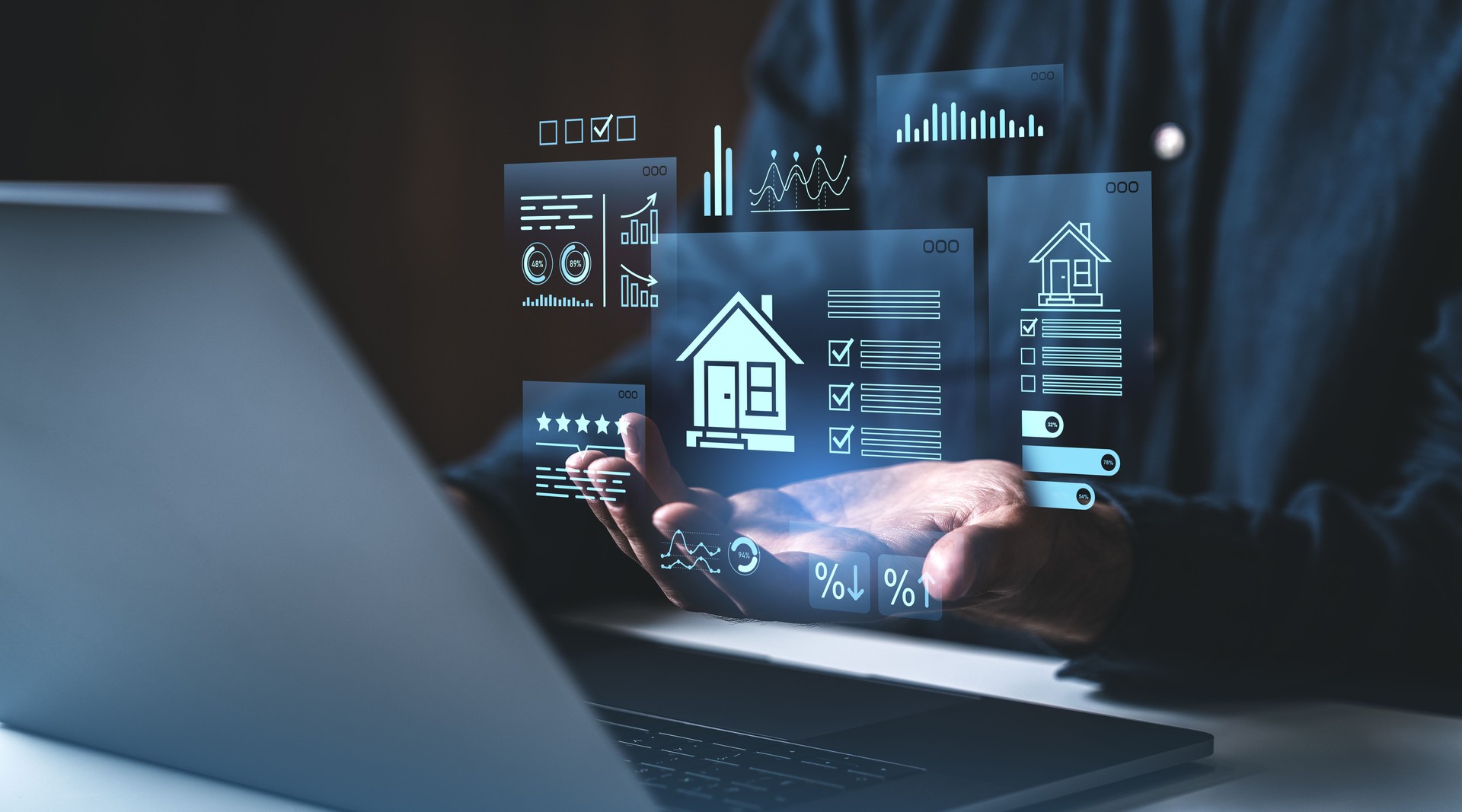 Digital real estate data analysis with futuristic holograms above laptop and hands on creative dark background concept of property investment technology.